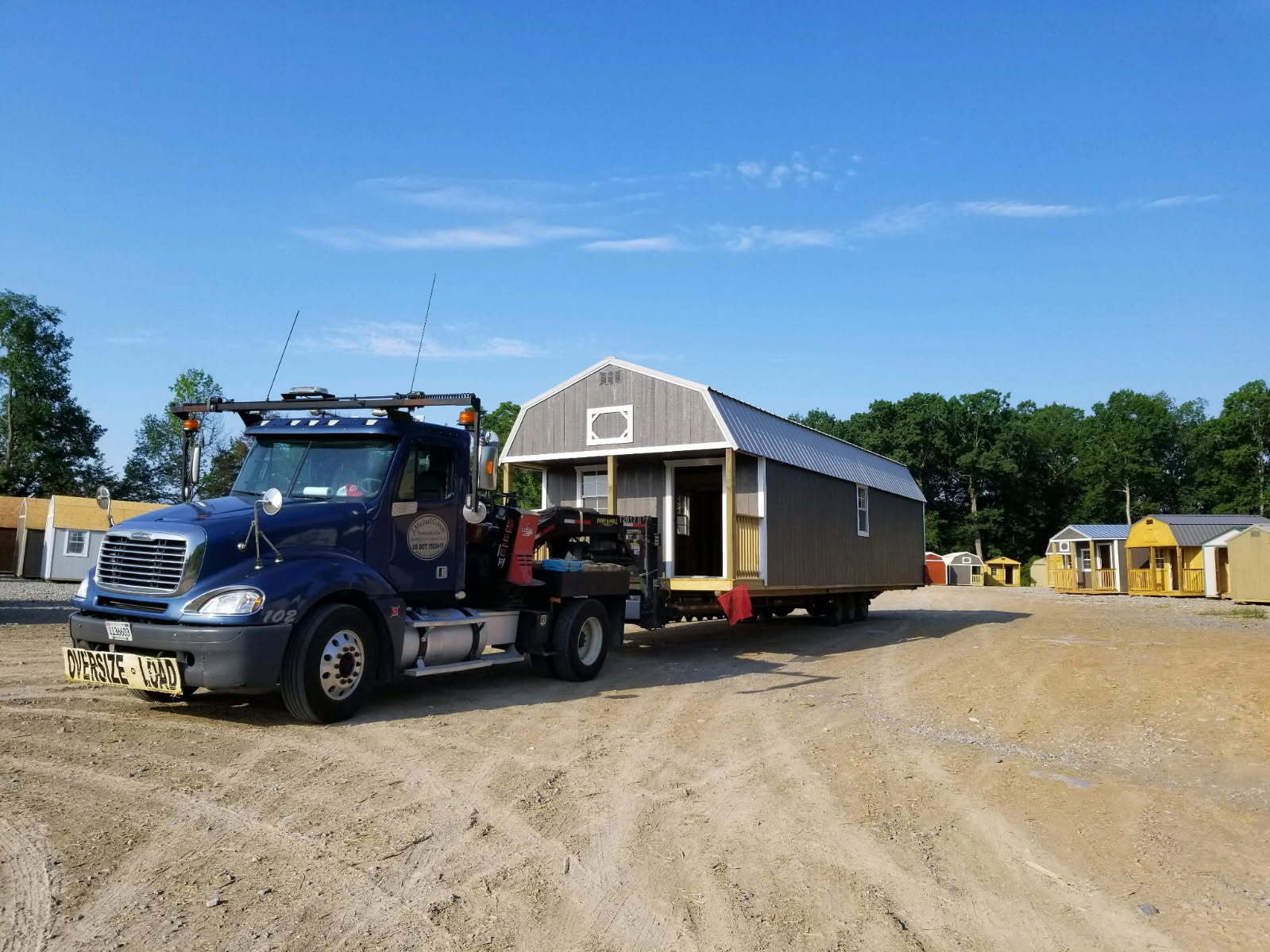 Cotton State Barns delivery truck carrying a storage building